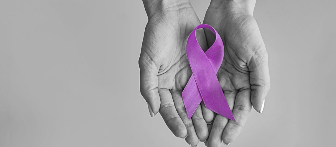 World cancer day inscription. healthcare and medicine concept - girl hands holding Purple cancer awareness ribbon